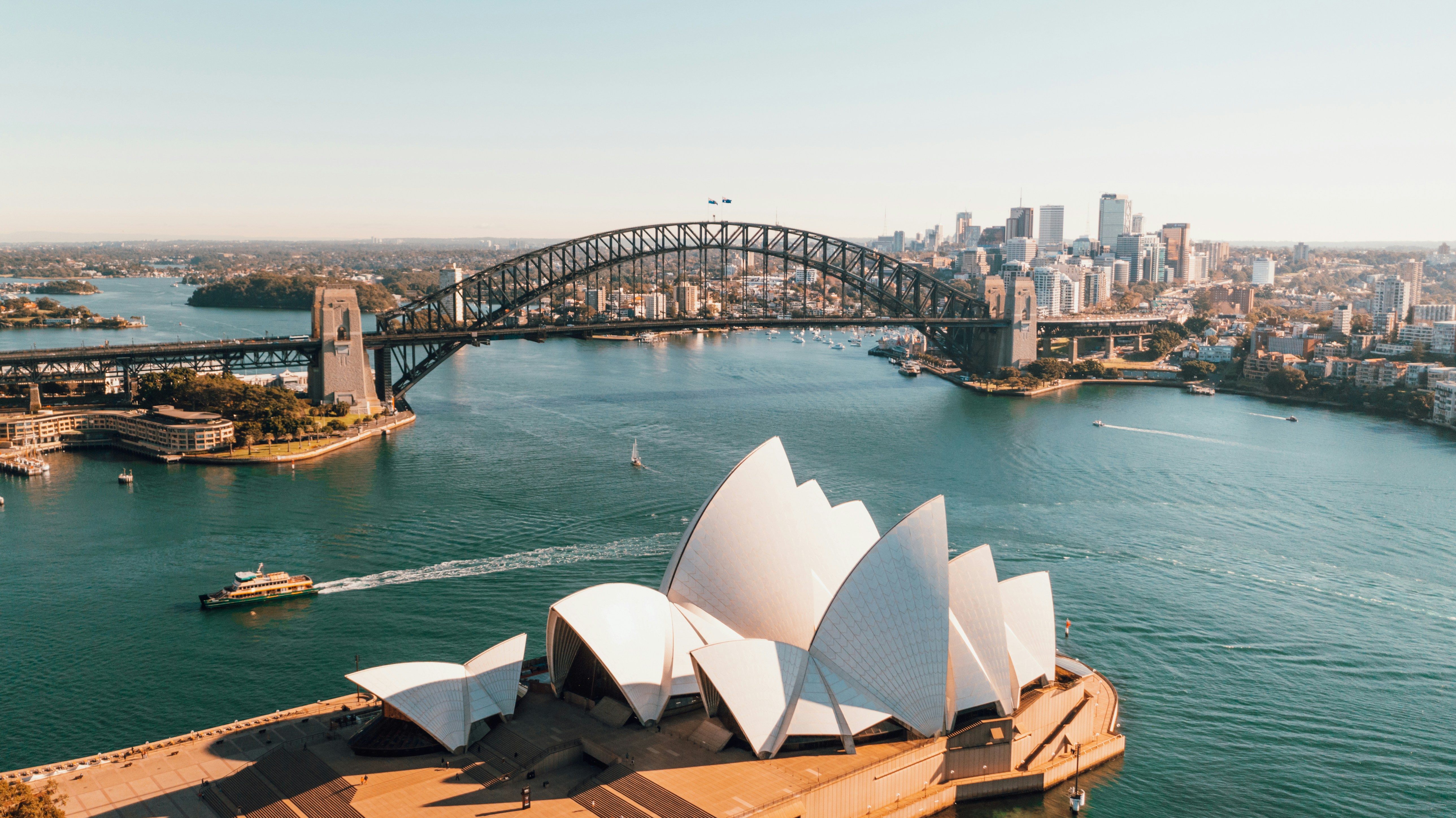 An overhead view of Sydney's Darling Harbour with the Harbour bridge and opera house.